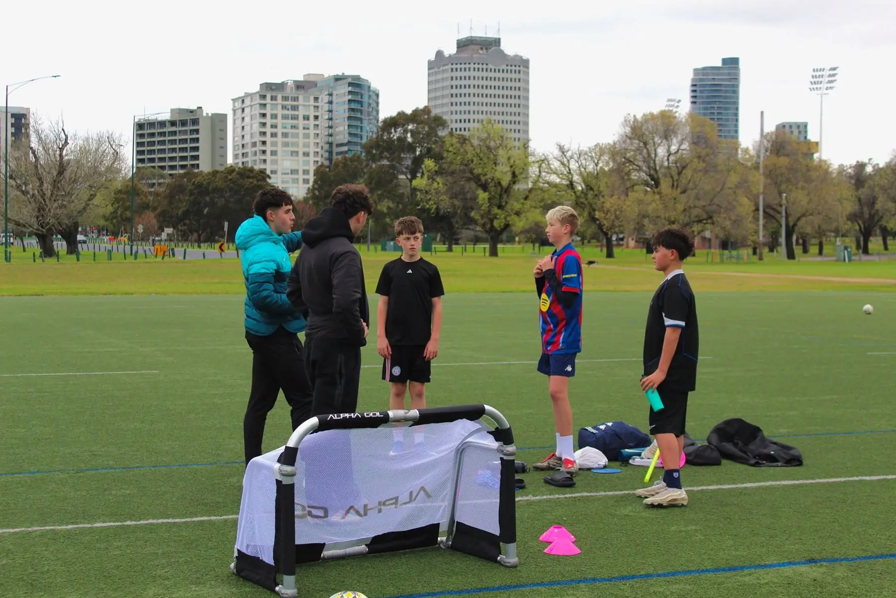 Coaches and players setting up a training session with the city skyline behind